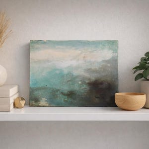 Puede incluir: Una estantería exhibe artículos de decoración del hogar. Una pintura con tonos turquesa y marrón se encuentra junto a un cuenco de madera y una planta en maceta. Un jarrón con hierba seca y una pila de libros completan el arreglo.