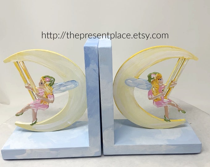 fairy bookends with a fairy swinging on a moon