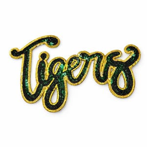 May include: A decorative patch with the word "Tigers" in a cursive script. The letters are filled with green beads and outlined with gold sequins. The patch is on a white background.