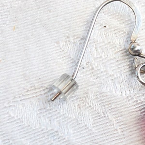 May include: Silver earring hook with a clear plastic stopper.