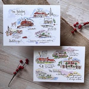 May include: Two watercolor greeting cards with travel-themed illustrations. One card is titled "The Holiday in Surrey" and the other "The Holiday in Los Angeles." Each card features hand-drawn images of landmarks and quotes.