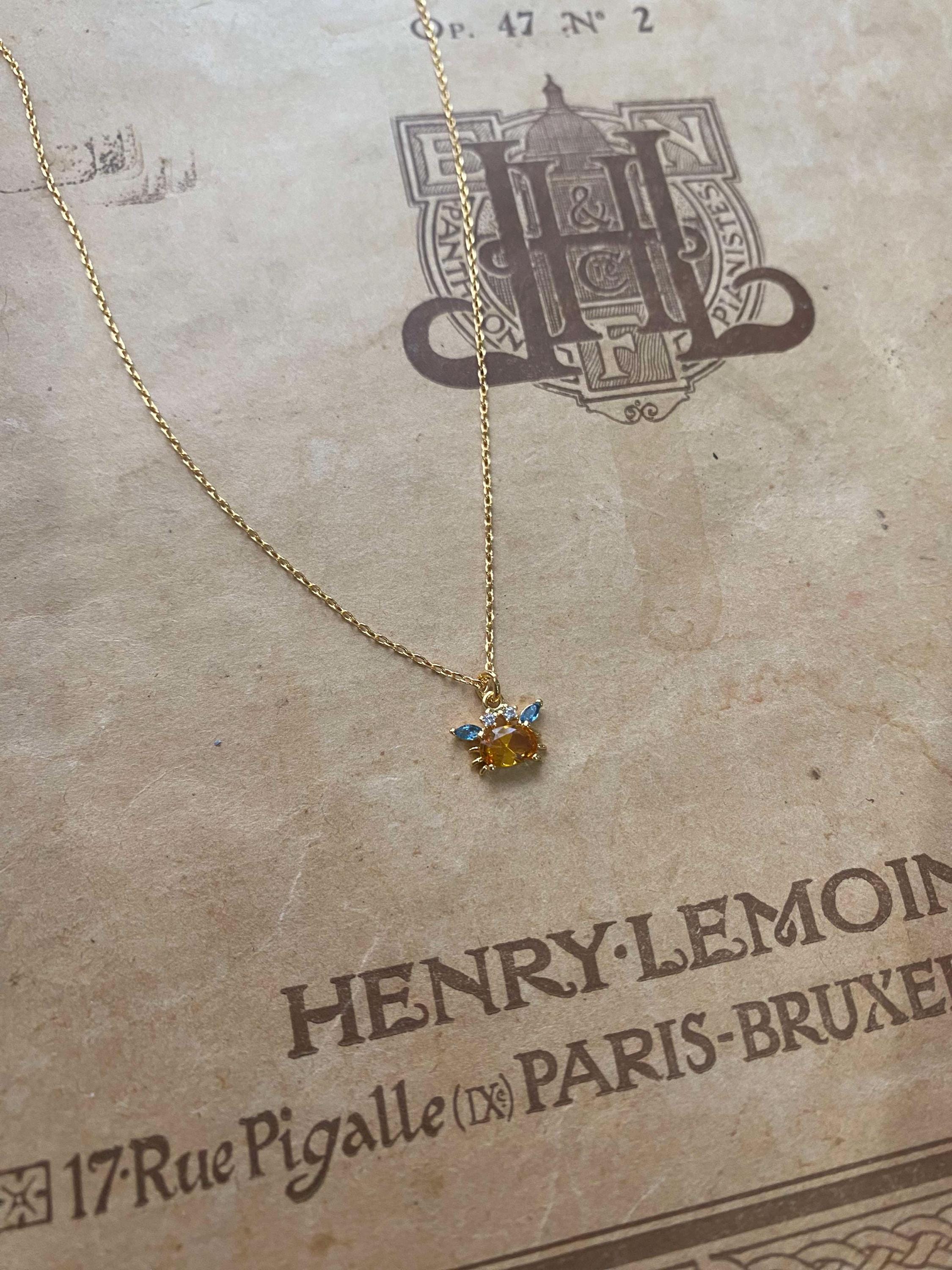 ゴールドカニネックレス – 繊細なクリスタルチャームにブルー