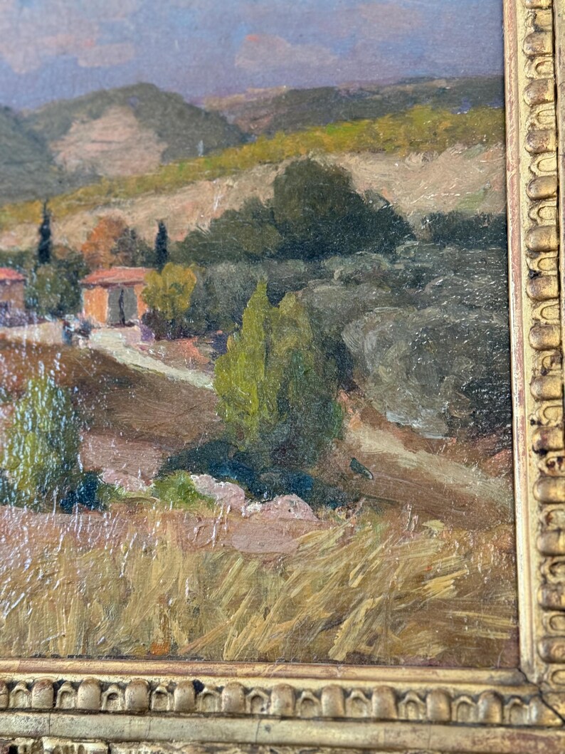 Puede incluir: Una pintura de un paisaje con colinas onduladas, un peque&ntilde;o pueblo y un camino sinuoso. El cielo es de un azul claro con nubes, y las colinas son una mezcla de verde y marr&oacute;n. El pueblo est&aacute; formado por unas pocas casas peque&ntilde;as, y el camino lleva hasta una colina en la distancia.