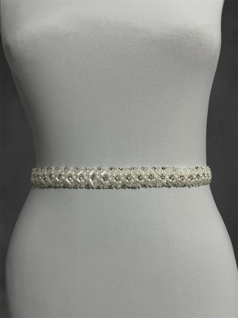 Handcrafted bridal belt adorned with sparkling crystals and pearls, designed to add elegance to your wedding gown. Delicate beadwork and intricate details make it a perfect accessory for a timeless bridal look.