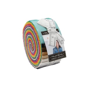 May include: A jelly roll of fabric strips featuring a vibrant rainbow color gradient on the edges, wrapped in a white paper band with the text Moda Fabrics + Supplies and a measuring tape graphic showing inches, against a plain white background.