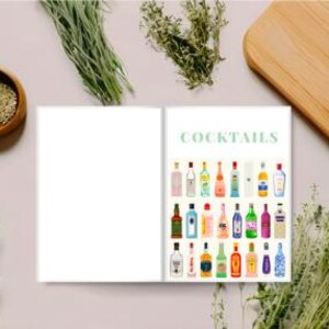 Op de afbeelding: Een open boek met het woord "COCKTAILS" in lichtgroen, met illustraties van verschillende drankflessen. De afbeelding bevat een houten snijplank, een kleine houten kom en kruidentakjes, wat wijst op een culinair thema.