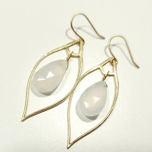 May include: Gold leaf-shaped earrings with white gemstone drops.