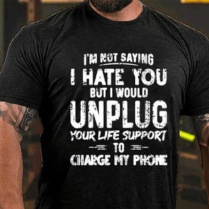 Puede incluir: Camiseta negra con texto blanco que dice "No estoy diciendo que te odio, pero desconectaría tu soporte vital para cargar mi teléfono."
