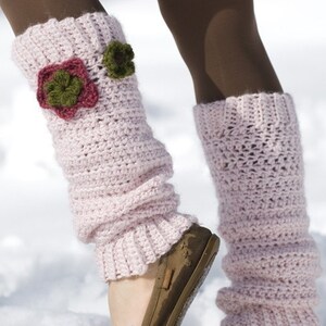 May include: Pink crocheted leg warmers with a flower design. The leg warmers are worn over brown tights and are folded down at the top.