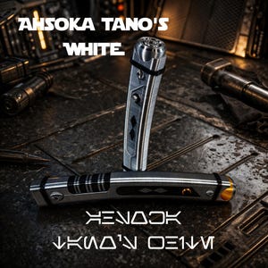 May include: A silver and black lightsaber with the text "Ahsoka Tano's White" above it. The lightsaber is lying on a textured surface with other metallic objects in the background. The text "XENADK" and "KNOW'N DENM" is below the lightsaber.