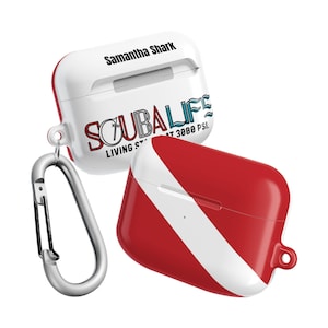 Puede incluir: Funda blanca y roja para AirPods con mosquetón plateado. La funda presenta el texto "Samantha Shark" y "SCUBA LIFE" con un diseño de bandera de buceo. Diseñada para proteger y transportar AirPods.