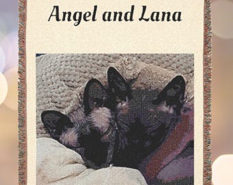 Może przedstawiać: Tkany koc z wizerunkiem dwóch kotów i napisem "Angel and Lana" w kolorze czarnym. Koc ma kremowe tło i frędzelkową obwódkę.