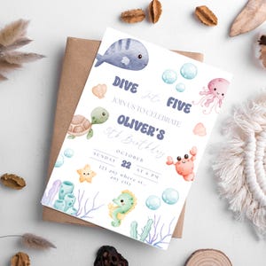 Op de afbeelding: Een blauwe en witte uitnodigingskaart met een aquarel-illustratie van een walvis, schildpad, krab, kwal en zeepaardje. De tekst op de kaart luidt "Dive into Five, Join us to celebrate Oliver's 5th Birthday, October 22, Sunday at 6 PM, 123 any where st., any city."