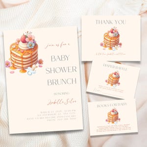 Op de afbeelding: Een uitnodiging voor een babyshower met een pannenkoekenillustratie en de tekst "Join us for a Baby Shower Brunch Honoring Isabelle Silva" met details over het evenement.