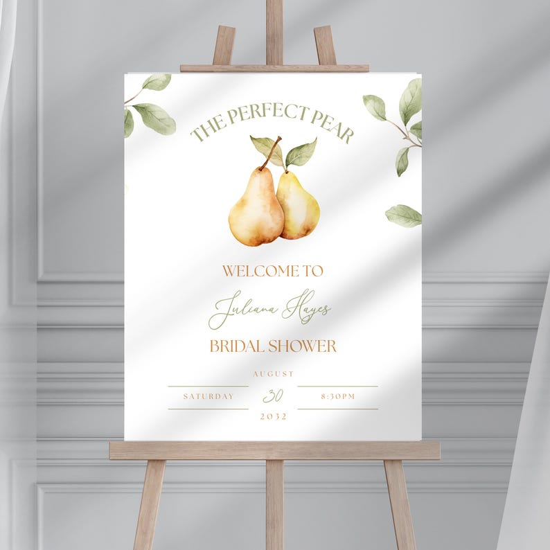 May include: A white sign on a wooden easel with the text "THE PERFECT PEAR" and "WELCOME TO Juliana Hayes BRIDAL SHOWER". The sign features watercolor illustrations of pears and leaves, with the date August 30, 2032.