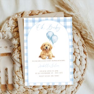 Op de afbeelding: Babyborrel uitnodiging met een aquarel illustratie van een golden retriever puppy met twee blauwe ballonnen. De uitnodiging heeft een blauw geruit patroon en bevat de tekst "Oh Baby" en evenement details.