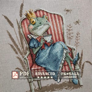 Peut inclure: Motif de point de croix d'une grenouille royale assise dans un fauteuil rayé, tenant une tasse à thé. La grenouille porte une couronne et une robe bleue. Le texte indique "PDF pattern", "Advanced" et "PK+SAGA compatible".