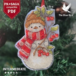 Cross stitch snowman ornament hanging on Christmas tree branch
