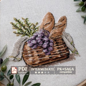 Puede incluir: Diseño de punto de cruz que muestra una cesta llena de uvas moradas, dos baguettes y ramitas verdes. La cesta es marrón y las uvas son de un morado intenso. El diseño está sobre una tela beige claro. El texto en la imagen dice "PDF pattern", "Intermediate" y "PK+SAGA compatible".
