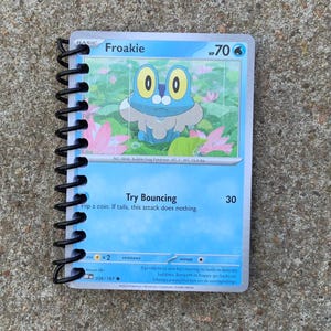 May include: A blue and white Pokemon trading card featuring Froakie, a blue frog Pokemon with yellow eyes. The card has the text "Froakie" and "HP 70" in the top right corner. The card also has the text "Try Bouncing" and "Flip a coin, If tails, this attack does nothing." in the bottom left corner. The card has the number "30" in the bottom right corner.