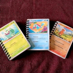 May include: Three small spiral bound notebooks with Pokemon character illustrations and card game stats. The notebooks feature Bulbasaur, Squirtle, and Charmander.