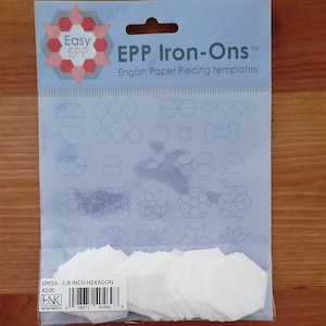 May include: A package of Easy EPP Iron-Ons English Paper Piecing templates. The package contains various shapes and a stack of 5/8 inch hexagon templates. The package has the text "EPP Iron-Ons" and "English Paper Piecing templates".