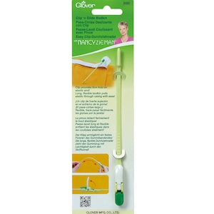 May include: Green and white plastic tool with a long, flexible needle. The tool is labeled "Clip 'n Glide Bodkin" and "Easy Clip-Durchziehnadel".