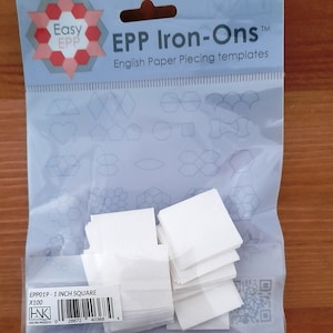 May include: A clear plastic packet of English Paper Piecing (EPP) templates. The packet reads "EPP Iron-Ons" and "English Paper Piecing templates". Inside are white paper squares, each measuring 2.54 cm. The packet also includes various EPP template shapes.