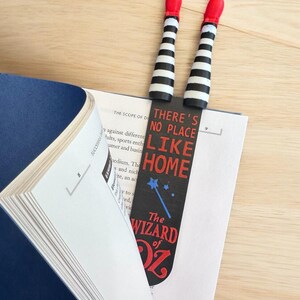 Wicked Witch Legs - striped black and white with Red Ruby Slippers.  Attached  to a bookmark reading " There's no place like home The Wizard of OZ"  The bookmark is placed in a book for display