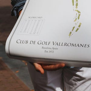 Può includere: Una mappa del campo da golf con un layout dettagliato del campo, che mostra fairway e bunker verdi. Sono visibili anche il segnapunti e il testo "CLUB DE GOLF VALLROMANES, Barcellona, Spagna, Est. 1972".