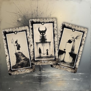 May include: Three tarot cards with dark, whimsical illustrations. The cards feature black and white drawings of figures and scenes, including a cloaked figure, a devil-like creature, and an angel. Each card has a decorative border and text at the bottom.
