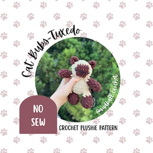 May include: A crochet plushie cat with a cream-colored body and dark brown ears, face, and limbs. The text on the image reads Cat Bubs-Tuxedo, NO SEW, CROCHET PLUSHIE PATTERN, and @audball_crochet. The plushie has a soft, textured yarn appearance.