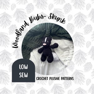 Pode incluir: Um bicho de pelúcia de gambá de crochê preto e branco com um nariz rosa e uma listra branca. O gambá está em um cobertor branco, com um cobertor de malha verde ao fundo. Texto: "Woodland Bubs- Skunk" e "Low Sew".