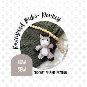 May include: A handmade crochet donkey plushie with gray, white, and black accents. The plushie is part of the "Barnyard Bubs" collection and is displayed on a green knitted blanket. The image also includes text that reads "Low Sew" and "Crochet Plushie Pattern."