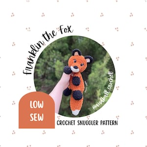 May include: A crocheted fox toy in shades of orange, black, and white, held against a blurred green background. The text "Franklin the Fox" arcs above the fox, with "LOW SEW" and "CROCHET SNUGGLER PATTERN" also visible.