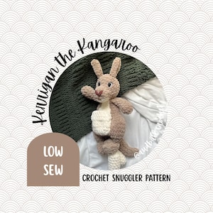 May include: A handmade crochet kangaroo toy in shades of brown and cream. The kangaroo has a pouch and is positioned on a green blanket and white fabric. Text on the image reads "Kerrigan the Kangaroo" and "Crochet Snuggler Pattern".