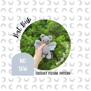 Può includere: Un pipistrello di peluche lavorato all'uncinetto di colore grigio con ali grigio chiaro e occhi scuri. L'immagine presenta il testo Bat Bub, NO SEW, CROCHET PLUSHIE PATTERN e @audball_crochet. Il peluche è mostrato su uno sfondo di fogliame verde.
