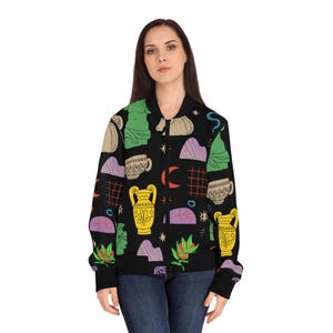 May include: Black bomber jacket featuring a repeating pattern of colorful illustrations. The design includes yellow vases, green statues, purple mountains, and white teacups. The jacket has a classic bomber silhouette with a zip-up front and ribbed cuffs.
