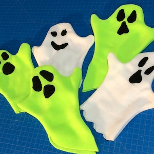 May include: Five felt ghost hand puppets, two are white with black eyes and a smiling mouth, and three are green with black eyes.