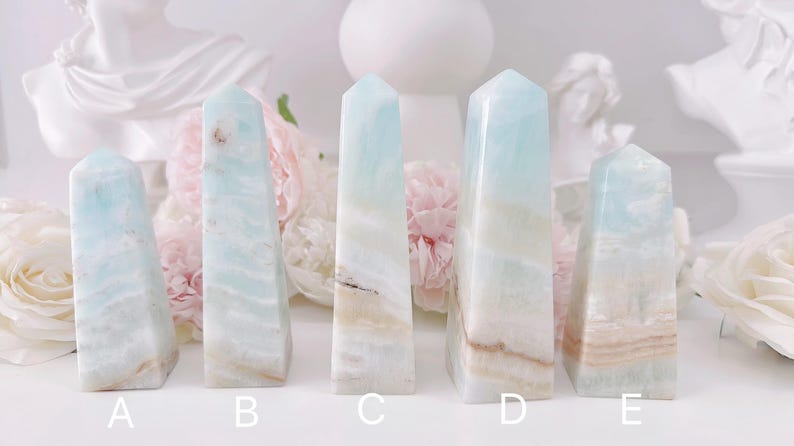 May include: Five blue and white crystal towers, labeled A through E, are arranged in a row on a white surface. The towers are all different sizes and shapes, with some having more white than blue and others having more blue than white.