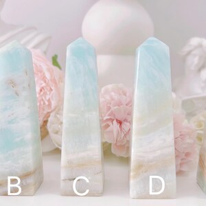 May include: Five blue and white agate crystal points, labeled A through E, arranged in a row on a white surface.