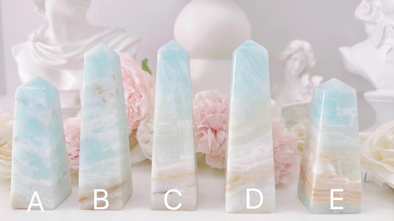 May include: Five blue and white agate crystal points, labeled A through E, arranged in a row on a white surface.