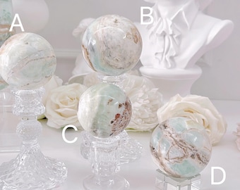 May include: Five green and white agate spheres on decorative stands. The spheres are various sizes and have a swirling pattern.