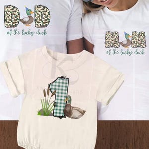 May include: A set of three white t-shirts with a duck and camouflage print. The shirts say "Dad of the lucky duck", "Mom of the lucky duck", and "1 of the lucky duck".