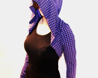 Puede incluir: Una estola con capucha de color morado y negro con estampado de pata de gallo y mangas largas.