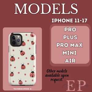 K&ouml;nnte beinhalten: Wei&szlig;es iPhone-Case mit einem Muster aus roten Marienk&auml;fern und kleinen roten Blumen. Das Case wird vor einem weinroten Hintergrund mit dem Text "MODELS" und "IPHONE 11-17" gezeigt. Weitere Modelle auf Anfrage.