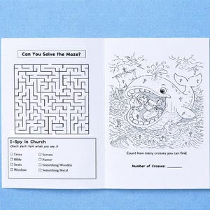 Pode incluir: Um livreto de atividades branco com ilustra&ccedil;&otilde;es em tinta preta. A p&aacute;gina esquerda apresenta um labirinto intitulado Can You Solve the Maze? e uma lista I-Spy in Church. A p&aacute;gina direita mostra um desenho de uma pessoa dentro de uma baleia com o texto Count how many crosses you can find e uma linha em branco para o Number of Crosses.