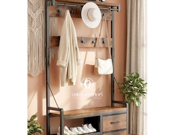 May include: A rustic entryway bench with a dark metal frame and a wooden top. It features a shelf for shoes, drawers, and a hanging rack for coats, hats, and bags. A white hat and purse hang from the rack. The bench is surrounded by potted plants.