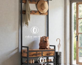 May include: A black metal and wood entryway organizer with a bench, shoe storage, and coat rack. A hat, scarf, and backpack are displayed on the organizer. The text "oaksy interiors" is visible.