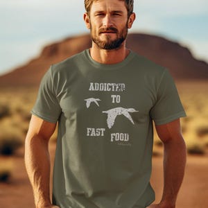 May include: A green t-shirt with a white graphic that says "Addicted to Fast Food" with a silhouette of a bird flying above the text.